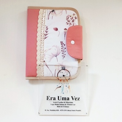 Estojo rosa e branco com padrão floral e renda, sobre papel com texto artístico.