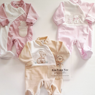 Três pijamas de bebé em tecido felpudo com bordados de animais em rosa, branco e bege