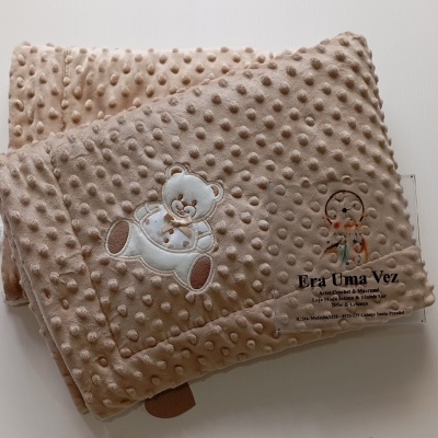 Cobertor bege com padrão bolinhas e bordado ursinho