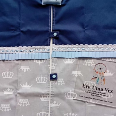 Cortina azul escura e cinza com padrão de coroas e decoração de coroa azul clara.