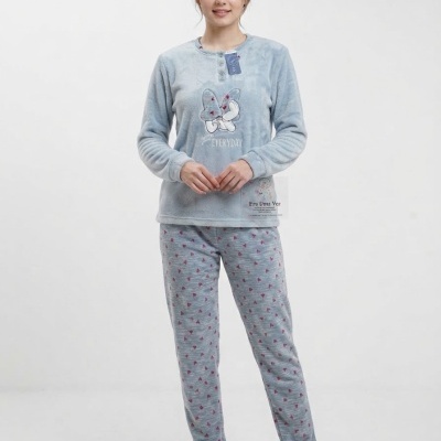Mulher a usar pijama azul claro felpudo com laço e texto EVERYDAY na blusa e calças com padrão de corações cor-de-rosa.