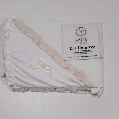 Manta branca com renda bege e laço, etiqueta Era Uma Vez com filtro dos sonhos
