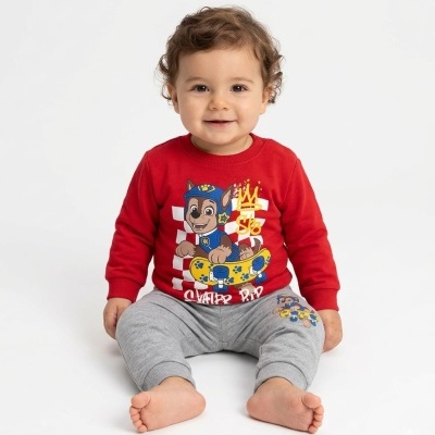 Bebé veste camisola vermelha com desenho de cão azul e calças cinzentas com detalhe do mesmo cão