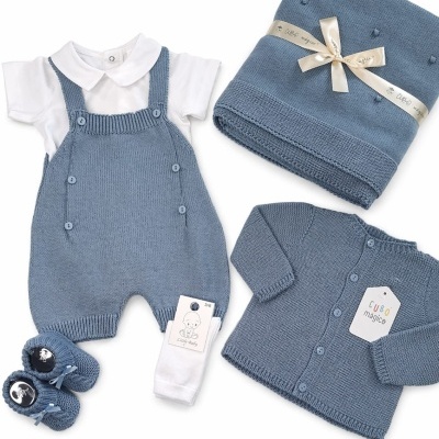 Conjunto de roupa de bebé azul com jardineiras, body branco, casaquinho, sapatinhos e manta
