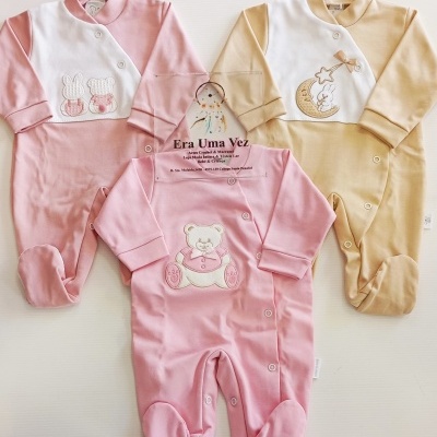 Três macacões de bebé rosa e bege com bordados e botões, placa transparente com texto Era Uma Vez