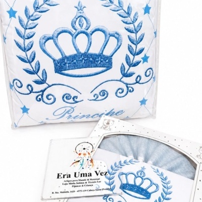 Conjunto de têxteis para bebé com padrão de estrelas e coroa azul, embalado numa caixa branca com ursinhos.