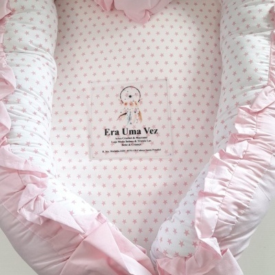 Ninho de bebé rosa com padrão de estrelas e almofada redonda