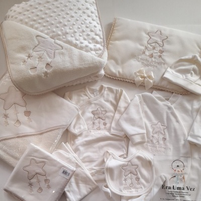 Conjunto de roupa e acessórios para bebé bege com bordado de estrela cinzenta em fundo branco