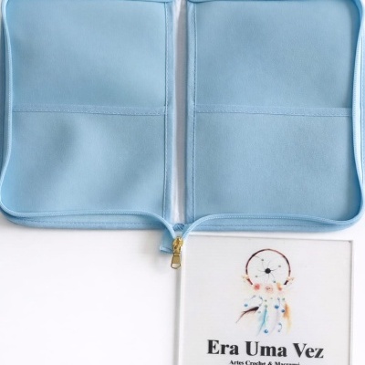 Estojo azul claro aberto com dois compartimentos e fecho dourado