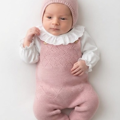 Bebé vestido com fato cor-de-rosa e camisola branca com gola plisada