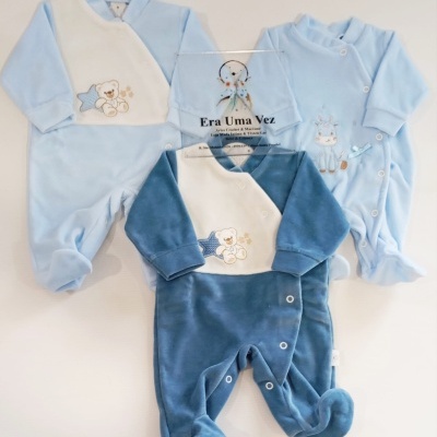Três macacões de bebé azuis de veludo com bordados, com botões de pressão.