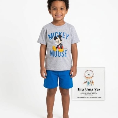 Criança com t-shirt cinza Mickey Mouse e calções azuis ao lado de quadro Era Uma Vez