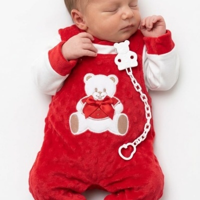 Bebé vestido com macacão vermelho com ursinho branco e camisa branca com punhos vermelhos