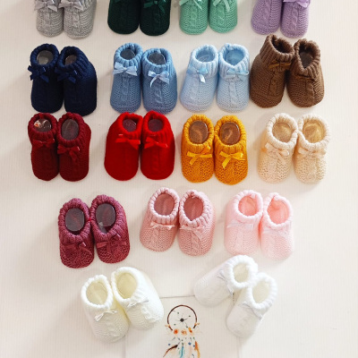 Sapatilhas de bebé em tricô coloridas com laço e placa com texto Era Uma Vez