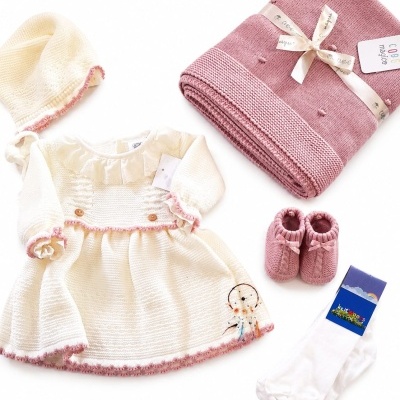 Conjunto de roupa de bebé com vestido branco e rosa, touca, sapatinhos, meias e manta rosa