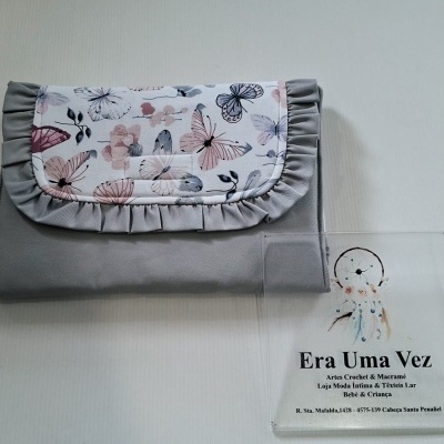Carteira cinza com aba decorada com padrão de borboletas e flores e cartão de loja