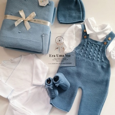 Conjunto de roupa de bebé azul e branco com jardineiras, body, sapatinhos, gorro e manta
