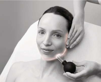 Mulher a receber tratamento facial com dispositivo preto e ponta metálica