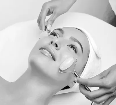 Pessoa a receber massagem facial com rolos de pedra rosa