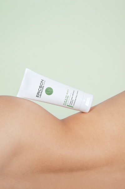 Creme corporal Ericson Laboratoire Paris em embalagem branca sobre pele.