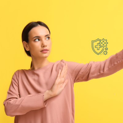 Mulher em camisola rosa com fundo amarelo, gesto de defesa, ícone de escudo verde