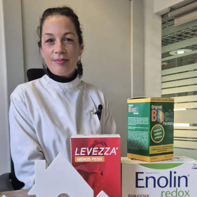 Mulher de bata branca com três embalagens de produtos de farmácia na frente