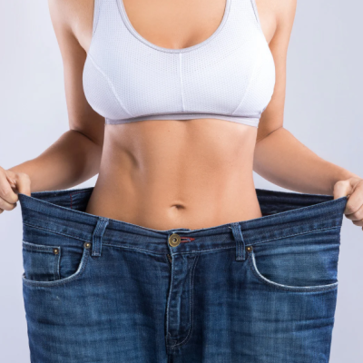 Pessoa de top branco segurando calças de ganga largas