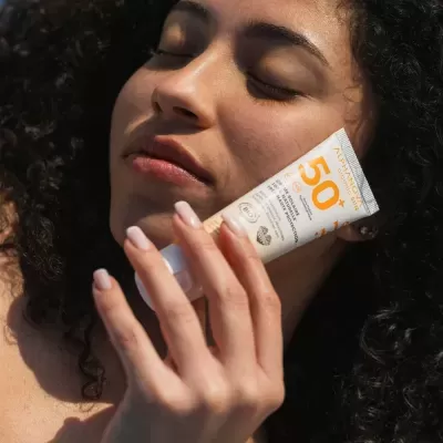 Mulher segurando tubo de protetor solar Avon Sun+ FPS 50