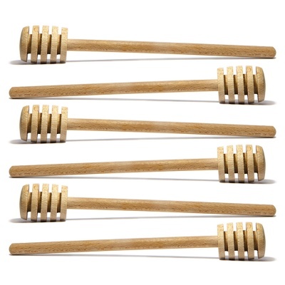 Seis colheres de mel em madeira clara com ranhuras sobre fundo branco