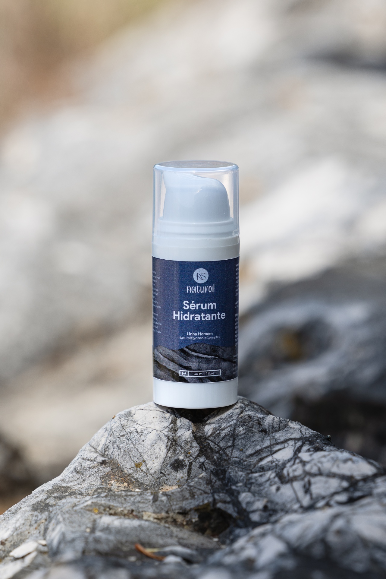 Sérum Facial Hidratante Frasco branco com tampa transparente de sérum hidratante natural colocado sobre pedra cinza