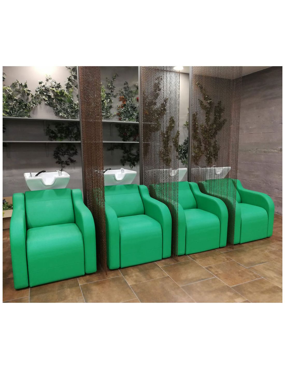 Cadeiras verdes estofadas com pias brancas e divisórias transparentes num salão