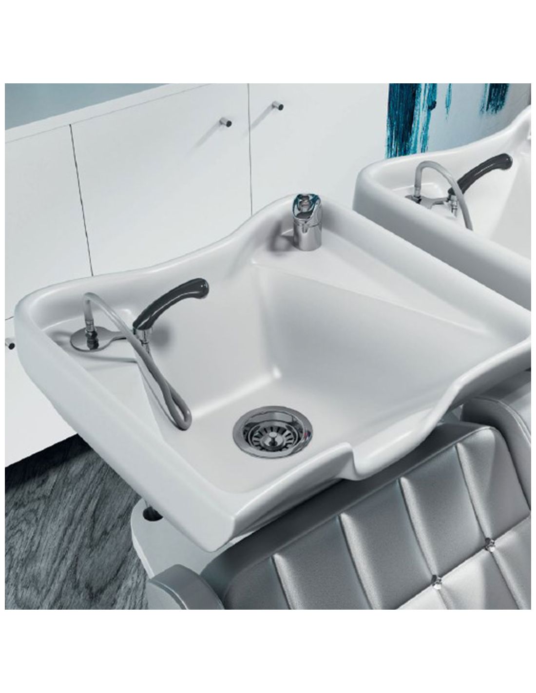 Lavatório cerâmico branco com torneira e mangueira preta, banco cinza acolchoado