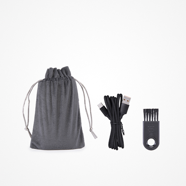 Saco cinzento, cabo USB preto e escova pequena preta com cerdas