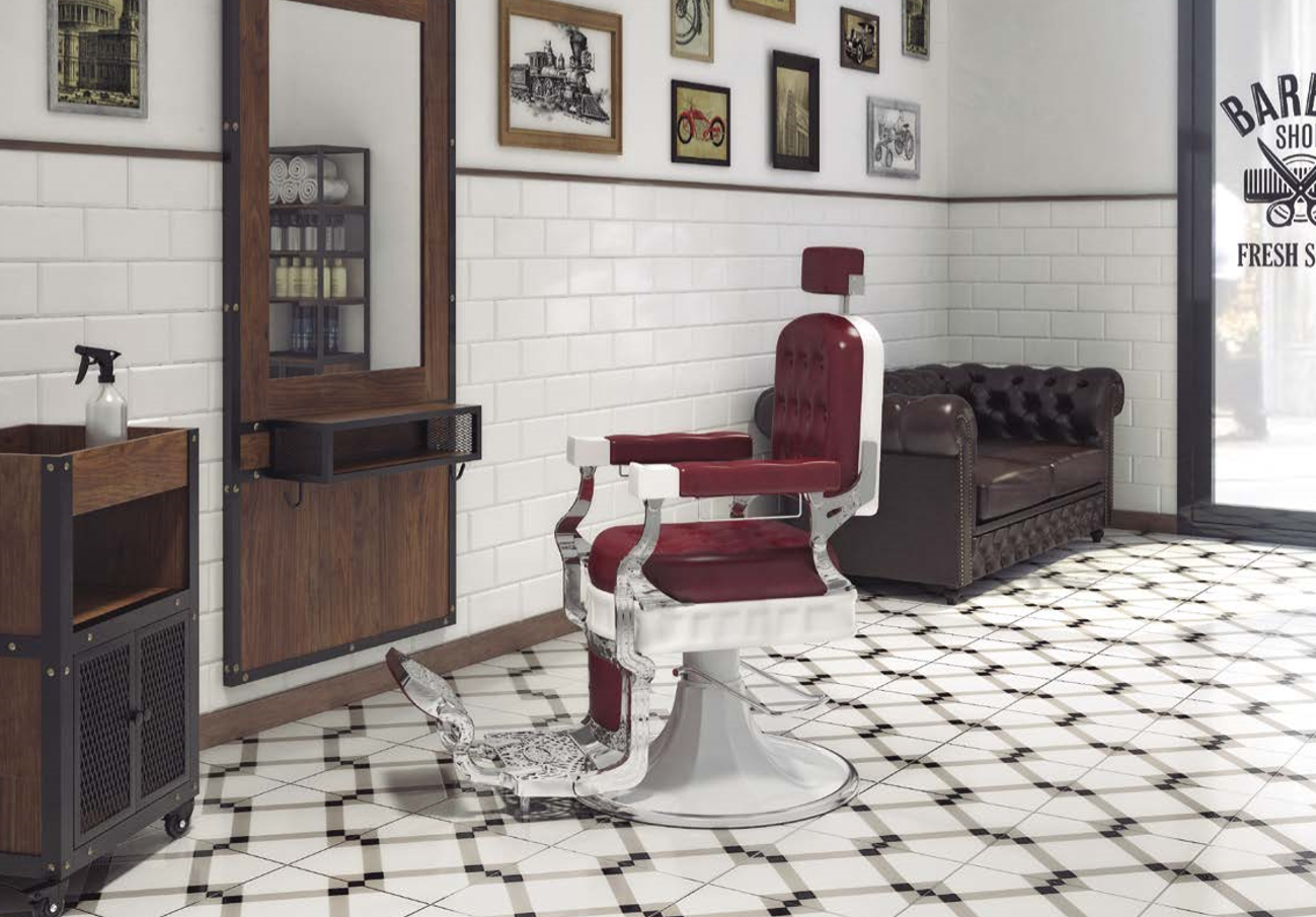 Cadeira de barbeiro vintage vermelha e branca num salão com chão xadrez e paredes de azulejos