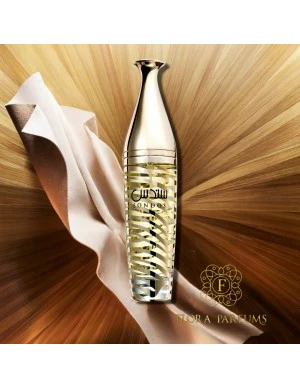 Frasco de perfume prateado e transparente com líquido amarelo, tecido bege e fundo dourado radiante