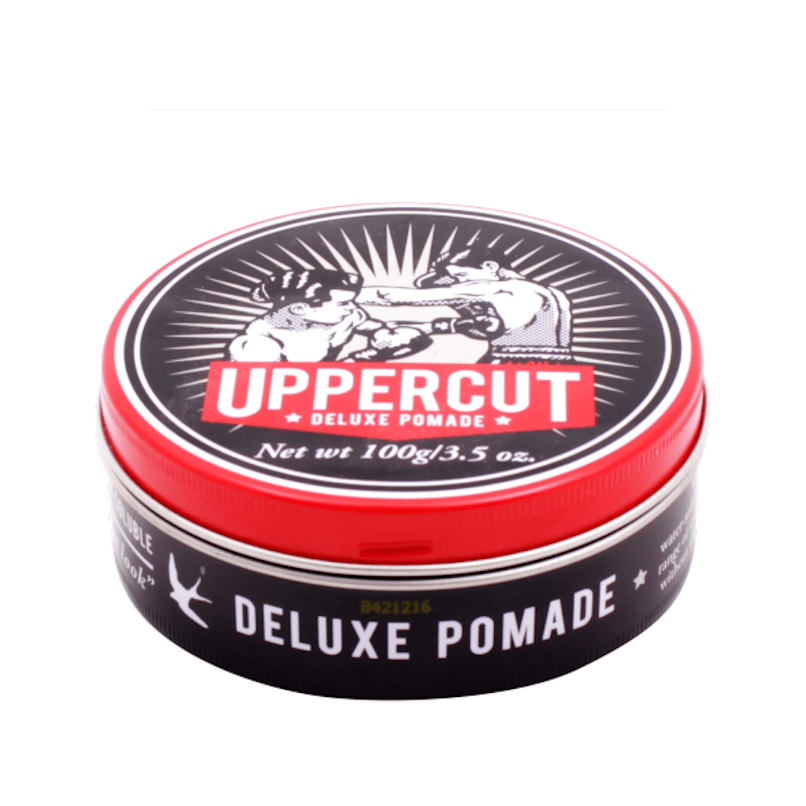 Pomada Uppercut Deluxe Pomade em embalagem redonda preta e vermelha com ilustração de boxeadores.