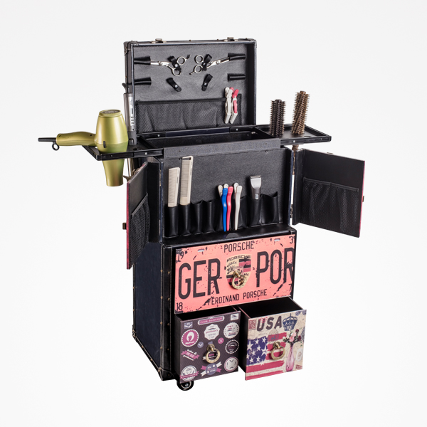 Mala de cabeleireiro preta com acessórios visíveis e decoração com texto 'GER POR' e temas dos EUA