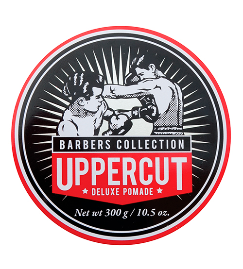 Lata redonda preta com ilustração de boxeadores e texto Uppercut Deluxe Pomade
