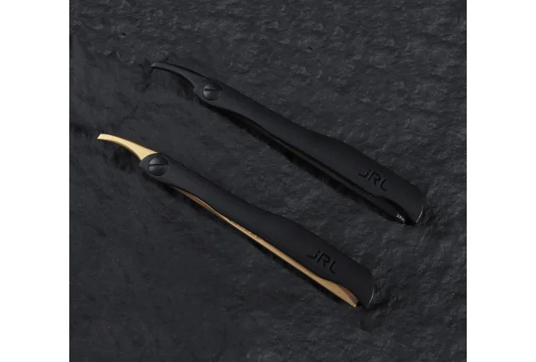 Dois instrumentos de cutícula pretos com lâminas curvas douradas sobre fundo escuro.