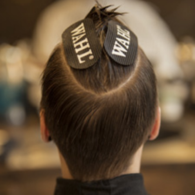 Parte de trás da cabeça com cabelo curto e presilhas WAHL num salão de cabeleireiro