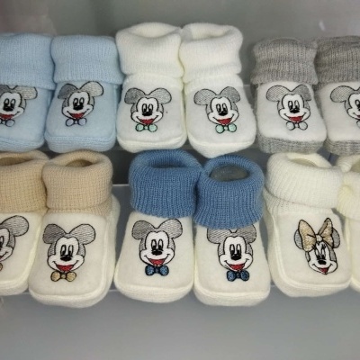 Meias de bebé em tecido de malha com bordados de Mickey e Minnie Mouse em várias cores.