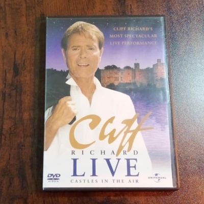 Capa de DVD de concerto ao vivo de Cliff Richard com castelo ao fundo
