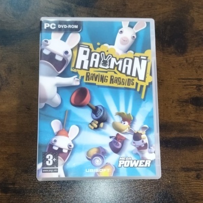 Capa de DVD-ROM do jogo Rayman Raving Rabbids para PC com personagens de coelhos e fundo azul
