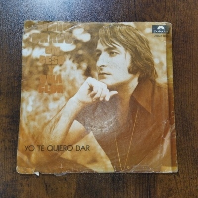 Capa de vinil castanha com imagem de homem e texto em espanhol