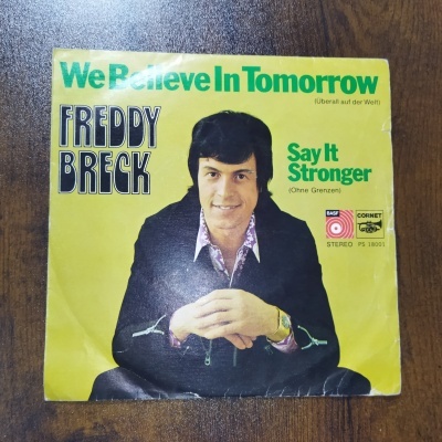 Capa de vinil amarelo com foto do artista Freddy Breck e texto We Believe In Tomorrow, Say It Stronger