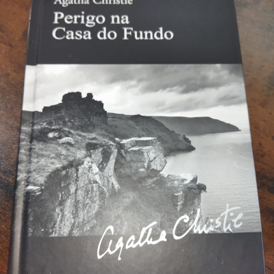 Capa de livro preto e branco com paisagem rochosa e título de Agatha Christie