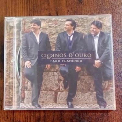 Capa de CD de fado flamenco com três homens vestidos de preto junto a uma parede de pedra