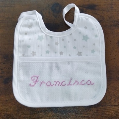 Babete branco com estrelas e nome 'Francisca' bordado em rosa