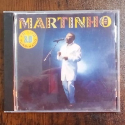 Caixa CD com capa do álbum MARTINHO com homem vestido de branco a cantar