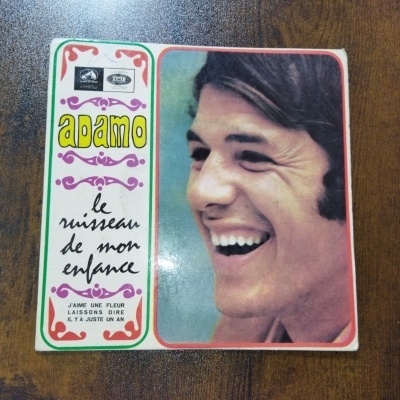 Capa de disco de vinil com fotografia de homem sorridente e texto em francês